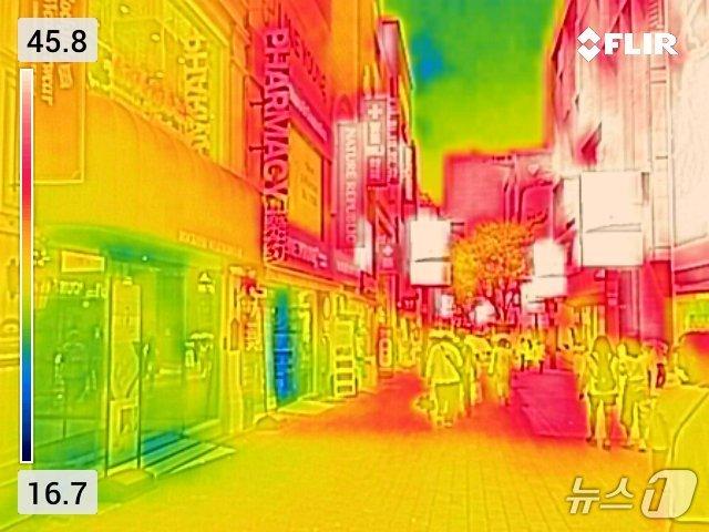 본문 이미지 - 서울 낮 최고기온이 38도에 근접한 7일 오후 서울 중구 명동거리의 에어컨을 키고 출입문을 연 매장들을 열화상카메라로 촬영한 모습. 열화상 카메라는 높은 온도는 붉은색으로, 낮은 온도는 파란색으로 표시된다. 2026.8.7 ⓒ 뉴스1 최지환 기자