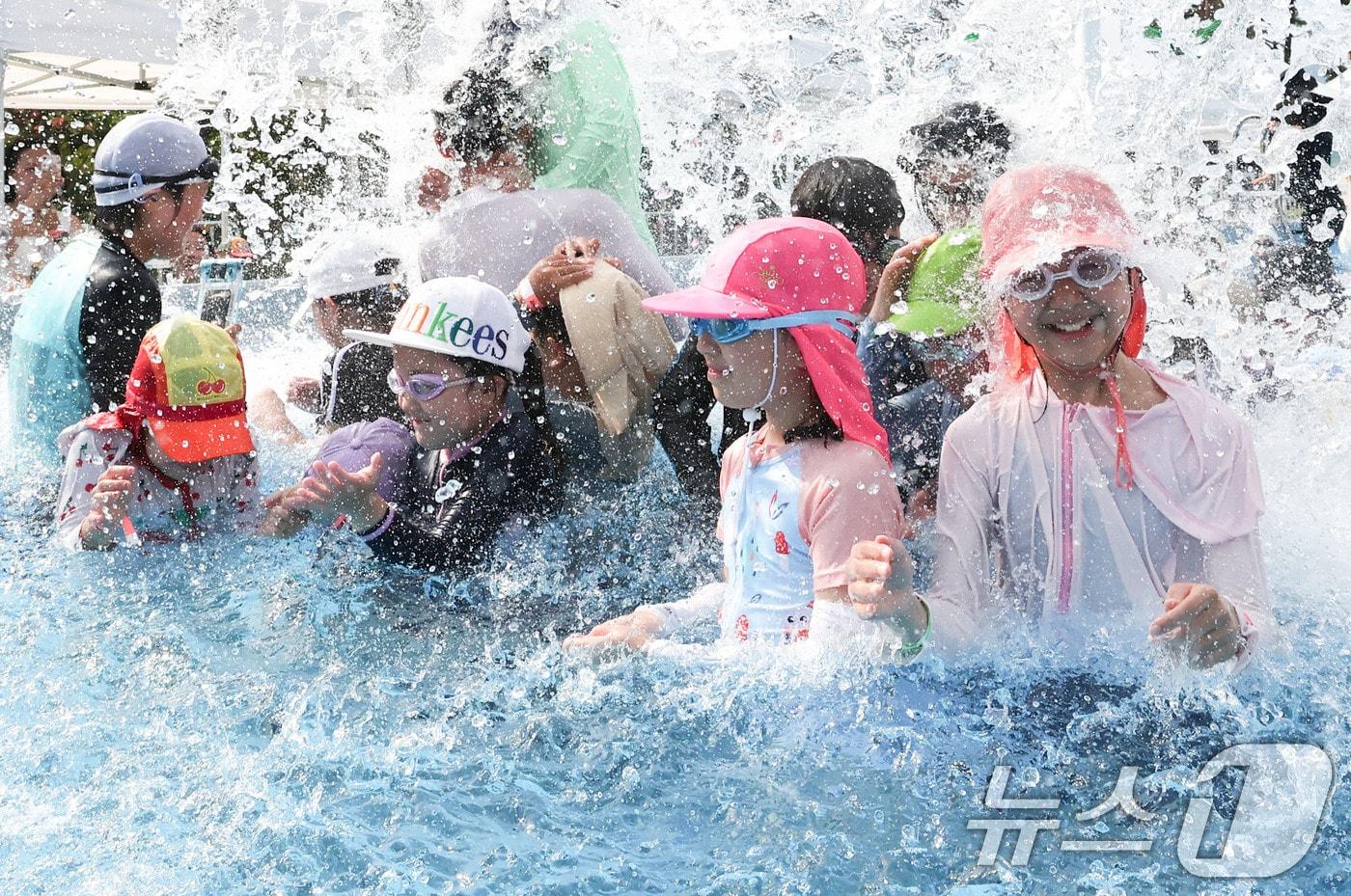 본문 이미지 - 기록적인 폭염이 이어지는 7일 서울 종로구 광화문광장에 마련된 ‘2026 서울썸머비치’를 찾은 아이들이 물놀이를 하며 더위를 식히고 있다. ⓒ 뉴스1 이종수 기자