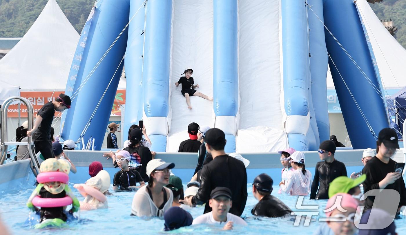 본문 이미지 - 기록적인 폭염이 이어지는 7일 서울 종로구 광화문광장에 마련된 ‘2026 서울썸머비치’를 찾은 아이들이 물놀이를 하며 더위를 식히고 있다. 2026.8.7 ⓒ 뉴스1 이종수 기자