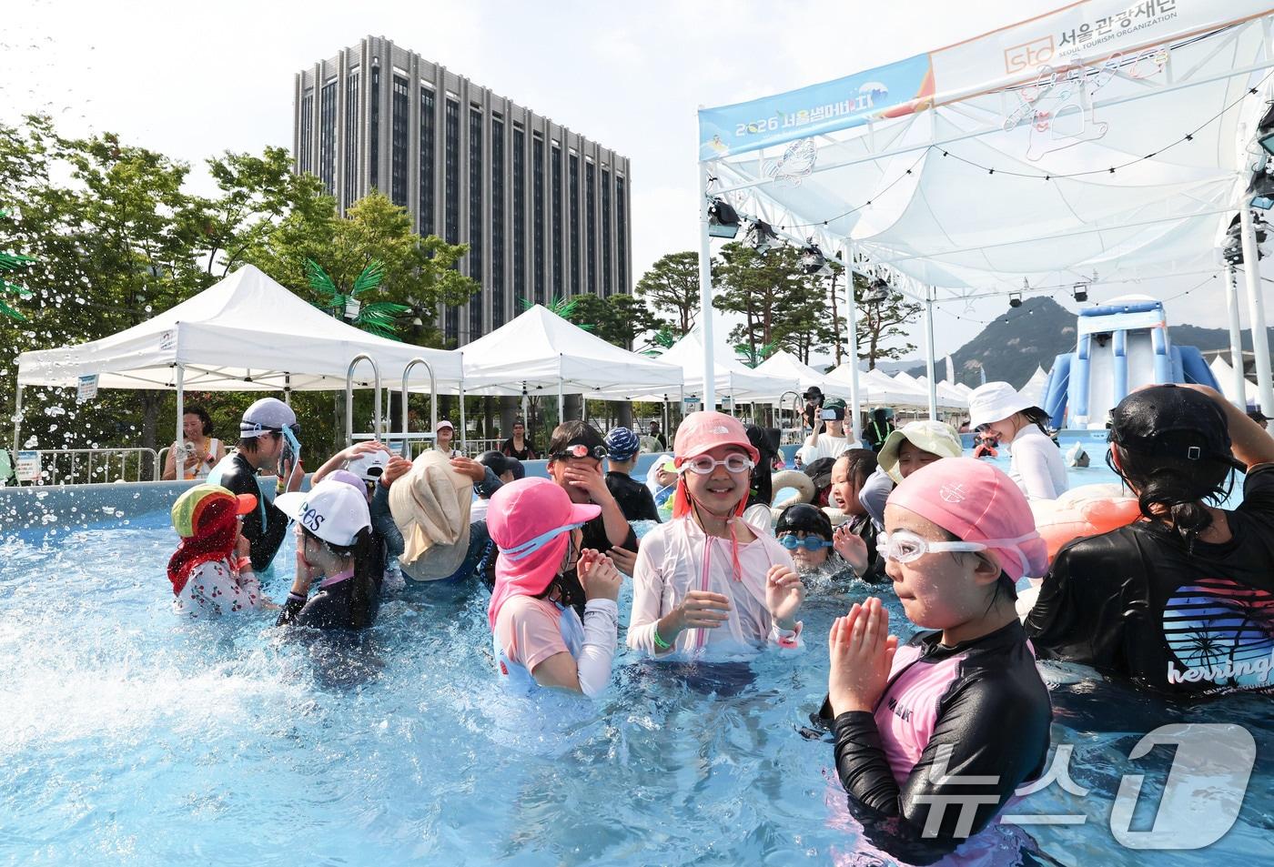 본문 이미지 - 기록적인 폭염이 이어지는 7일 서울 종로구 광화문광장에 마련된 ‘2026 서울썸머비치’를 찾은 아이들이 물놀이를 하며 더위를 식히고 있다. 2026.8.7 ⓒ 뉴스1 이종수 기자