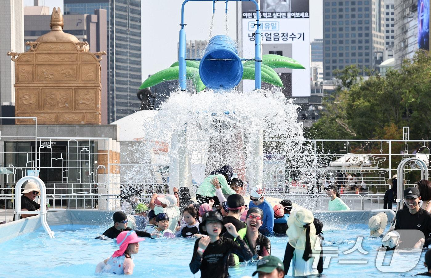 본문 이미지 - 기록적인 폭염이 이어지는 7일 서울 종로구 광화문광장에 마련된 ‘2026 서울썸머비치’를 찾은 아이들이 물놀이를 하며 더위를 식히고 있다. 2026.8.7 ⓒ 뉴스1 이종수 기자