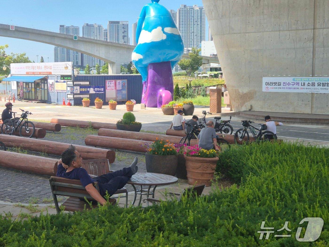 본문 이미지 - 폭염특보가 이어지고 있는 8일 오후 인천 서해구 아라뱃길에서 휴식을 취하고 있는 시민들/뉴스1