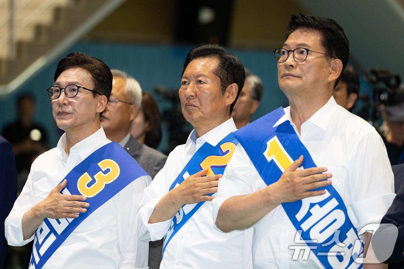 본문 이미지 - 더불어민주당 김민석(왼쪽부터), 정청래, 송영길 당대표 후보가 9일 강원 횡성군 횡성국민체육센터에서 열린 더불어민주당 당대표 및 최고위원 선출을 위한 강원 순회경선 합동연설회에서 국민의례를 하고 있다. 2026.8.9 ⓒ 뉴스1 유승관 기자