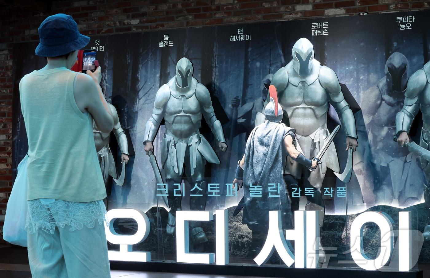본문 이미지 - '오디세이' 포스터를 보고 있는 시민ⓒ 뉴스1 김진환 기자