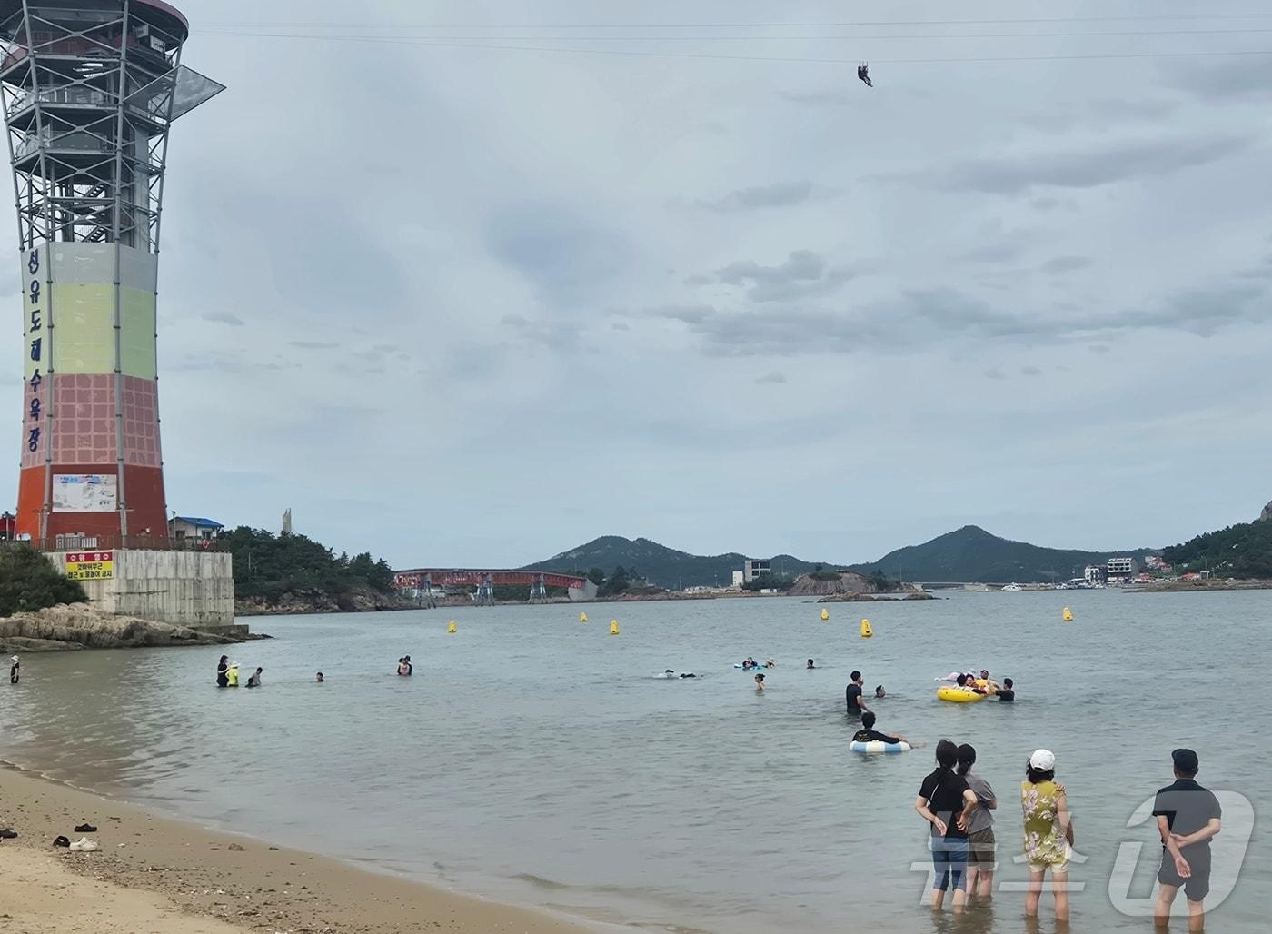 본문 이미지 - 9일 전북 군산시 선유도해수욕장에서 피서객들이 짚라인을 바라보고 있다.2026.8.9 ⓒ 뉴스1 강교현 기자
