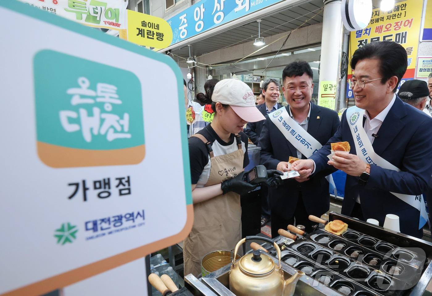 본문 이미지 - 허태정 대전시장이 1일 온통대전 2.0 출범을 기념해 대전 동구 중앙시장에서 진행된 시민과 함께하는 장보기 행사에서 온통대전으로 결재하고 있다. 대전시는 온통대전 2.0 출범을 계기로 캐시백, 정책 지원, 정보무늬(QR코드) 결제 등 다양한 서비스를 확대해 시민의 일상 소비와 지역경제를 연결하는 시민생활경제 플랫폼으로 발전시켜 나갈 계획이다. 2026.9.1 ⓒ 뉴스1 김기태 기자