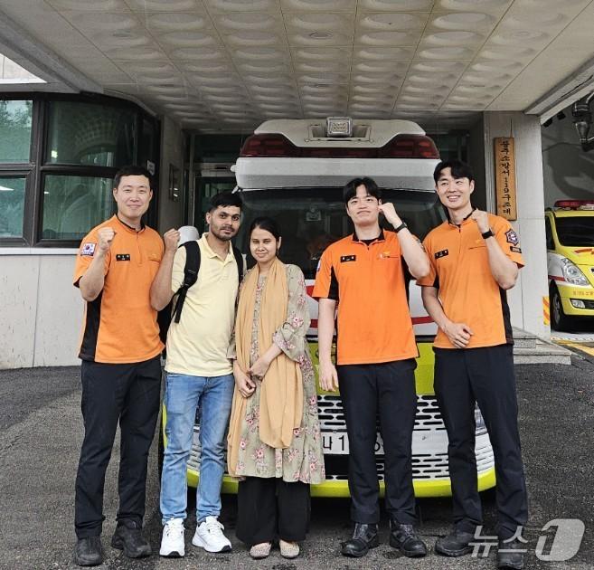 본문 이미지 - 달리던 구급차 안에서 출산한 방글라데시 국적의 부부와 당시 응급 분만을 도왔던 경기 광주소방서 구급대원들 모습.(광주소방서 제공)
