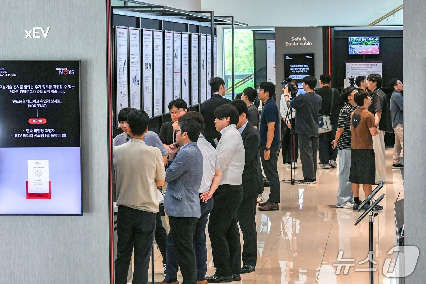 본문 이미지 - 경기도 용인시 기술연구소에서 열리고 있는 '2026 현대모비스 R&D 테크데이'에 업계 관계자들이 방문해 전시품을 관람하고 있는 모습.(현대모비스 제공)