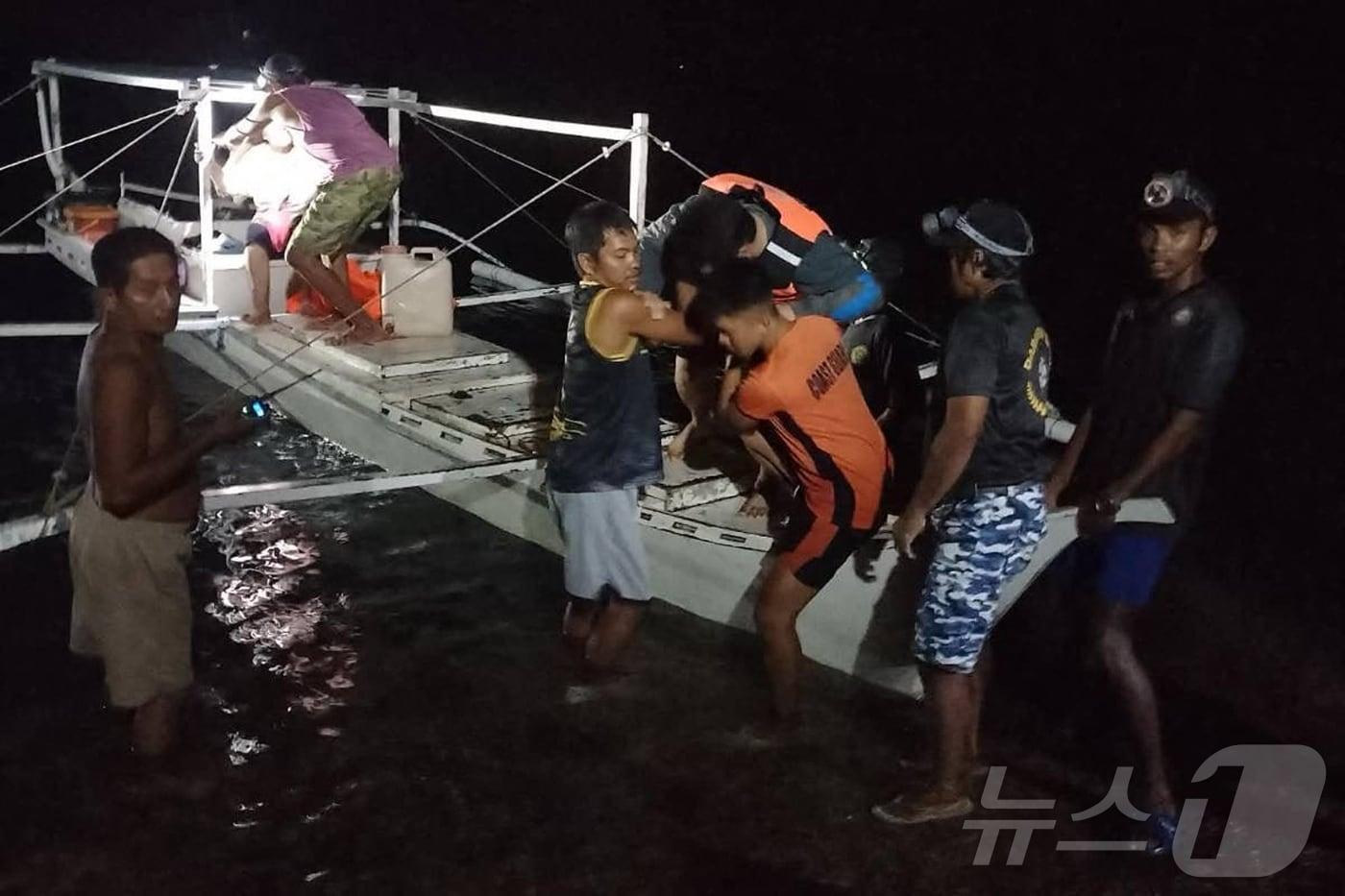본문 이미지 - 필리핀 어민 자원봉사자가 9일(현지시간) 팔라완 인근 해상에서 화재가 발생한 여객선의 생존자들을 구조하고 있다. 2026.9.9 ⓒ AFP=뉴스1