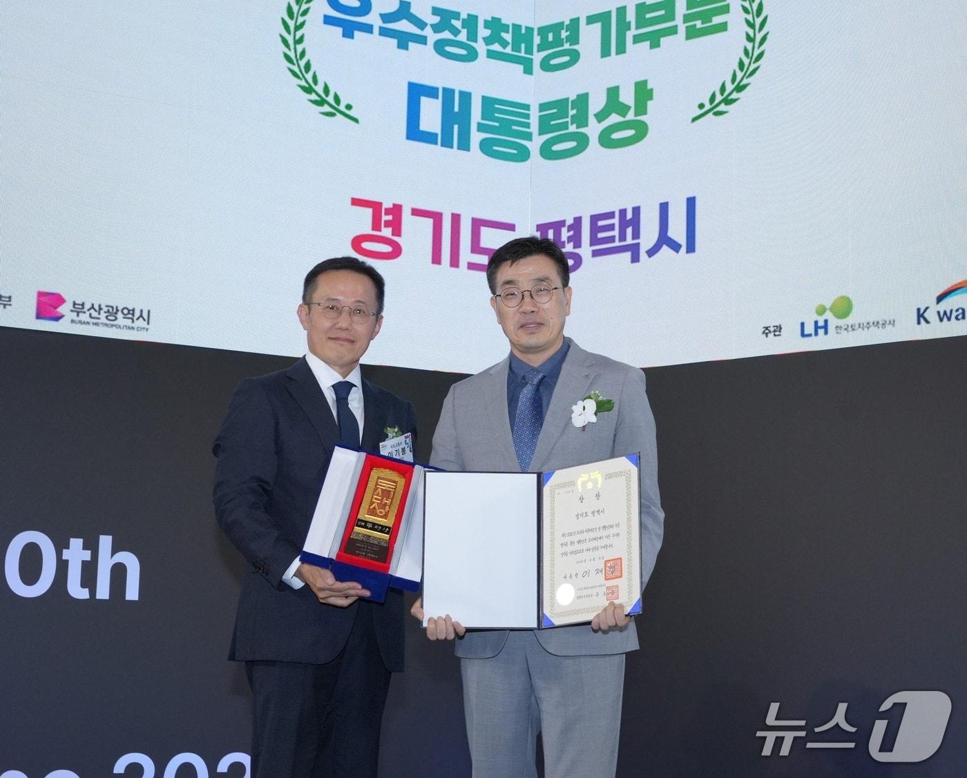 본문 이미지 -  부산 전시컨벤션센터(BEXCO)에서 열린 '2026 대한민국 도시대상' 시상식에서 최원용 평택시장(오른쪽)이 대통령상을 받은 뒤 기념촬영을 하고 있다. (평택시 제공)