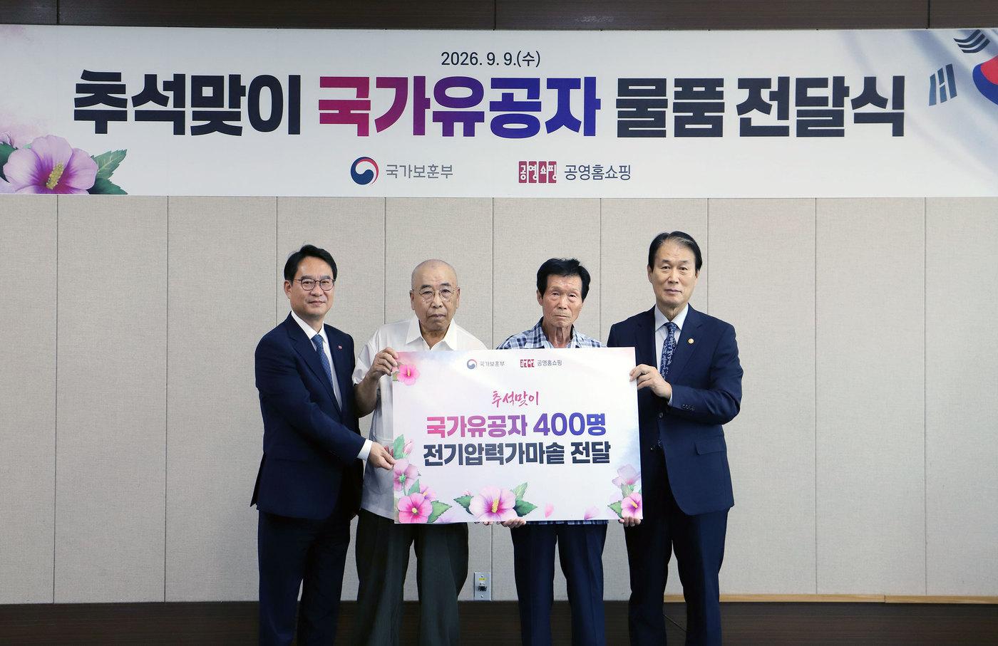 본문 이미지 - 이일용 공영홈쇼핑 대표이사(왼쪽), 국가보훈부 권오을 장관(오른쪽)과 국가유공자들이 기념사진을 찍고 있다.(공영홈쇼핑 제공)