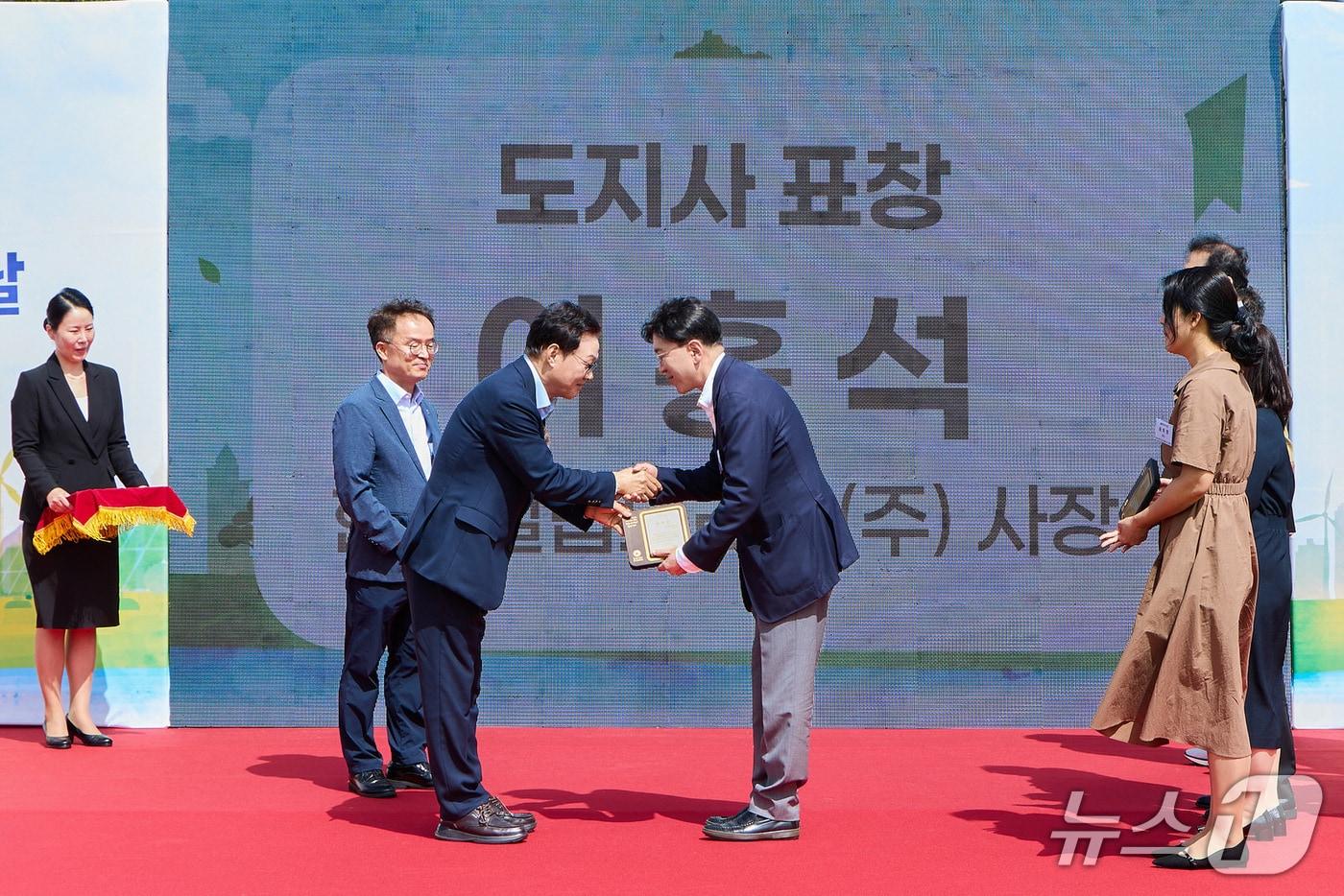 본문 이미지 - 4일 양산 황산공원에서 열린 '2026년 환경의 날 및 자원순환의 날 통합 기념행사'에서 김주한 한국필립모리스 부사장(오른쪽)이 박완수 경남도지사로부터 표창을 받고 있다(한국필립모리스 제공). 2026.9.11/뉴스1