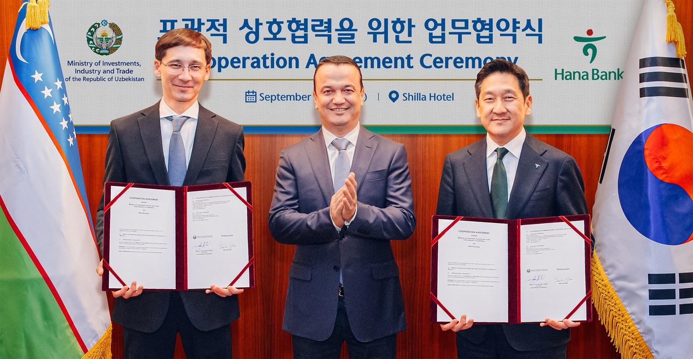 본문 이미지 - 하나은행은 지난 11일 오후 우즈베키스탄 투자산업통상부와 투자·금융 협력을 위한 업무협약을 체결했다. 협약식에 참석한 윤태선 하나은행 글로벌사업본부 본부장(사진 오른쪽)이 라지즈 쿠드라토프 우즈베키스탄 투자산업통상부 장관(사진 가운데), 굴라모프 우즈베키스탄 투자산업통상부 차관(사진 왼쪽)과 함께 협약서를 들고 기념촬영을 하고 있다.(하나은행 제공)
