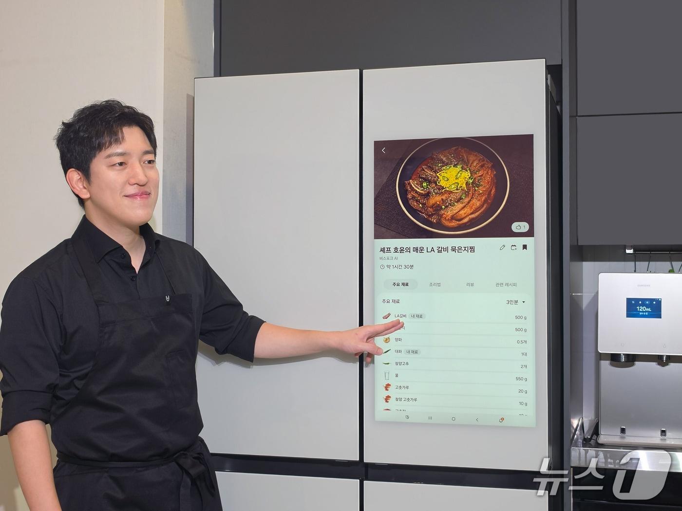 본문 이미지 - 삼성전자가 서울 용산구 한남동 소재 '셰프 호윤 스튜디오'에서 비스포크 인공지능(AI) 주방 가전의 편리함을 소개하고자 개최한 '비스포크 AI 쿠킹쇼'에서 김호윤 셰프가 '비스포크 AI 패밀리 허브' 냉장고로부터 보유 식재료를 활용한 메뉴 '매운 LA갈비 묵은지찜'을 추천받고 있다(삼성전자 제공). 2026.9.13.