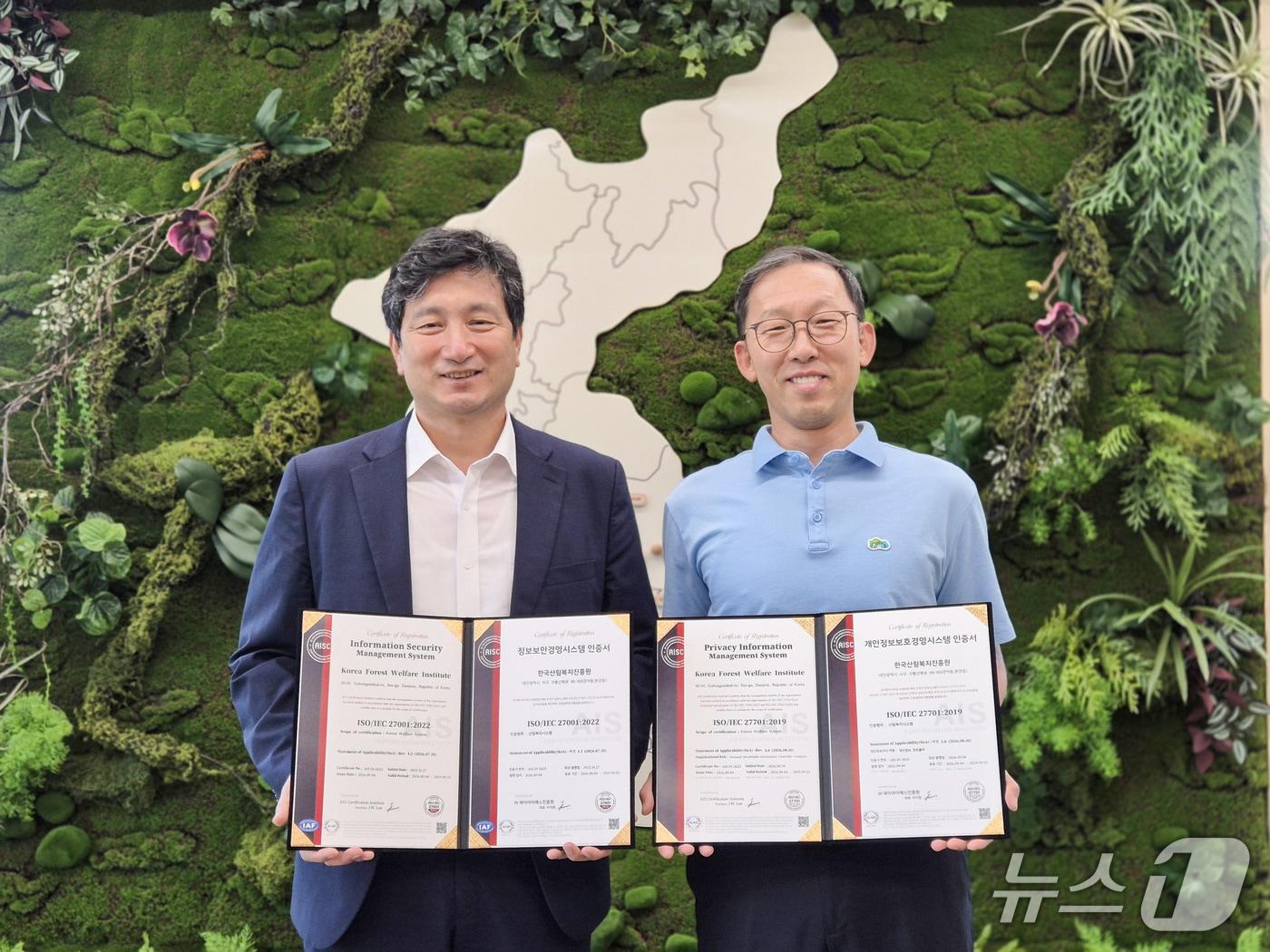 본문 이미지 - 정연국 한국산림복지진흥원 원장 직무대행(왼쪽)과 정보보안팀 김재식 팀장이 정보보안경영시스템(ISO27001), 개인정보보호경영시스템(ISO27701) 인증 기념촬영을 하고 있다. (한국산림복지진흥원 제공. 재판매 및 DB금지) /뉴스1