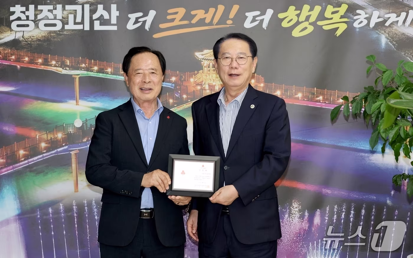 본문 이미지 - 송인헌 괴산군수(오른쪽)이 14일 이민성 충북사회복복지공동모금회장으로부터 나눔리더 인증패를 받은 뒤 기념촬영을 하고 있다.(괴산군 제공. 재판매 및 DB 금지).2026.9.14/뉴스1