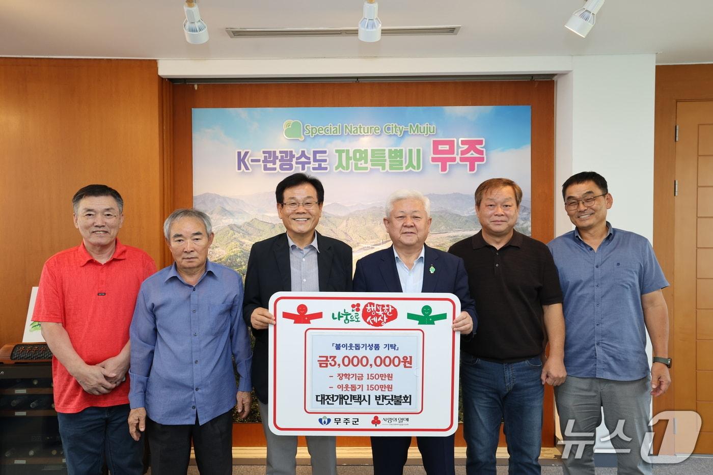 본문 이미지 - 대전 개인택시 반딧불회가 14일 전북 무주군에 이웃 돕기 성금 등 총 300만 원을 기탁한 뒤 황인홍 무주군수(가운데)와 기념촬영을 하고 있다. (무주군 제공. 재판매 및 DB 금지)