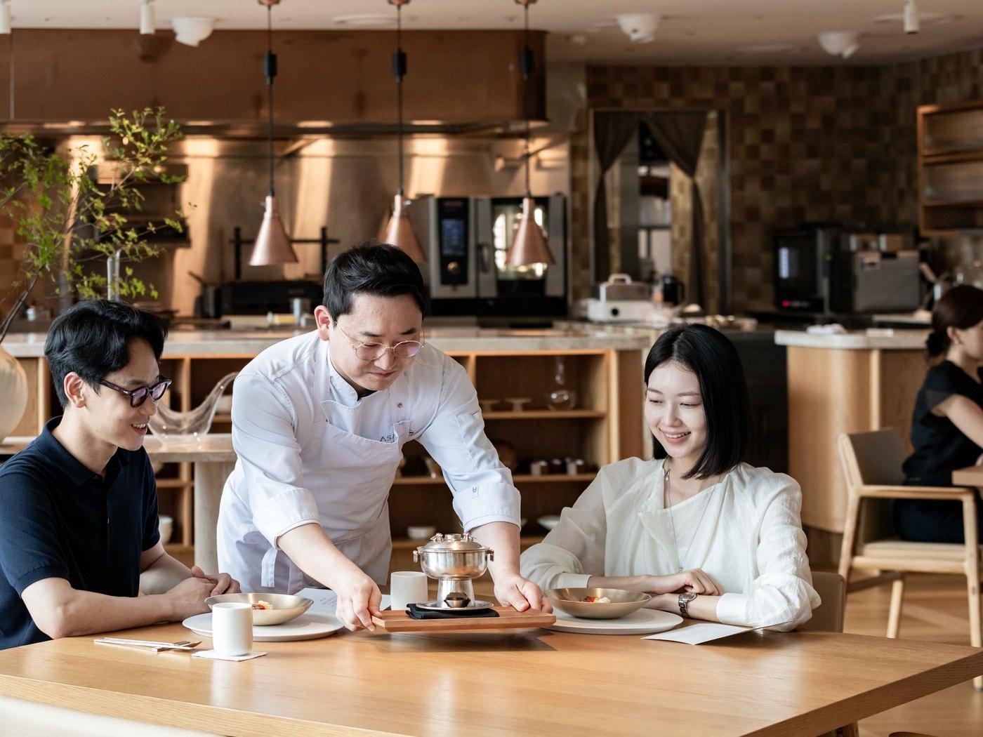 본문 이미지 - 김정환 아사달 셰프가 민어만두 소개를 위해 신선로를 내려놓고 있다.(한화푸드테크 제공)