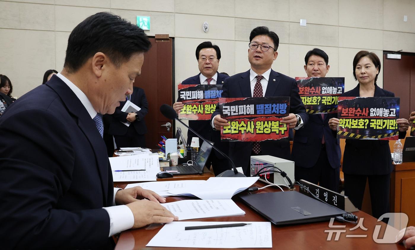 본문 이미지 - 15일 서울 여의도 국회에서 열린 행정안전위원회 전체회의에서 국민의힘 행안위 위원들이 ‘보완수사 원상복구’라고 적힌 손팻말을 김영진 행안위원장에게 들어 보이고 있다. 국민의힘 행안위 위원들은 이후 회의장에서 퇴장했다. 2026.9.15 ⓒ 뉴스1 박지혜 기자