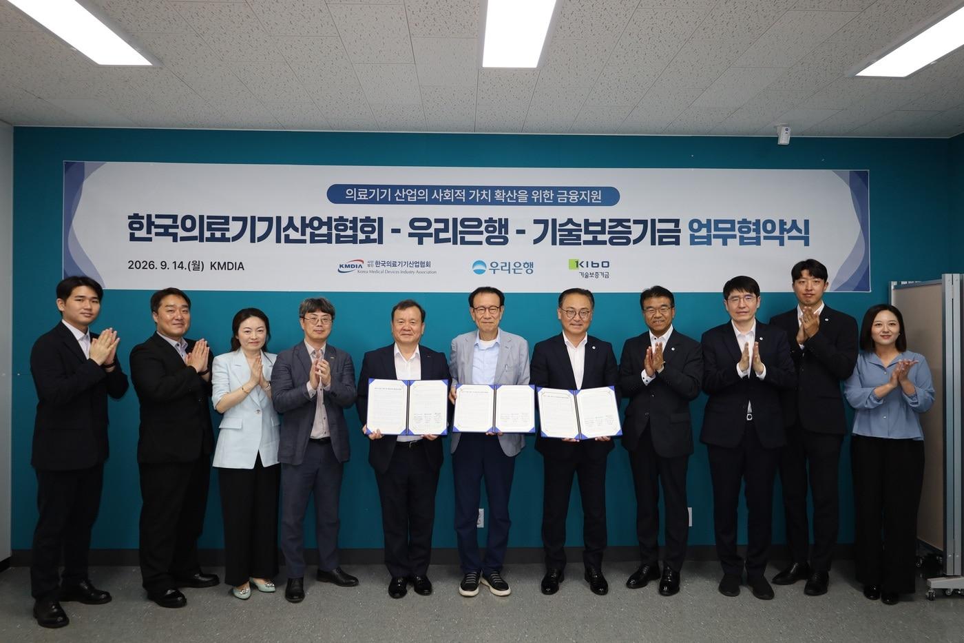 본문 이미지 - 왼쪽에서 다섯번째부터 이재필 기술보증기금 이사, 김명정 한국의료기기산업협회 상근부회장, 배연수 우리은행 기업그룹장을 포함한 협약참석자들이 기념사진을 찍고 있다.(기술보증기금 제공)