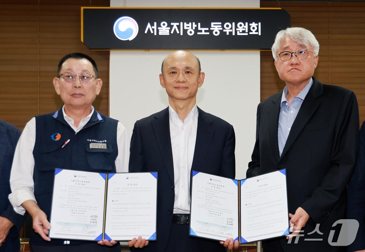 본문 이미지 - 박점곤 서울시버스노동조합 위원장(왼쪽부터), 권병희 서울지노위 조정위원장과 김정환 서울시버스사업조합 이사장을 비롯한 참석자들이 16일 서울 영등포구 서울지방노동위원회에서 열린 특별조정위원회 2차 사후 조정 회의에서 서울 시내버스 노사 협상에 극적으로 합의한 뒤 기념촬영을 하고 있다. 2026.9.16 ⓒ 뉴스1 이호윤 기자
