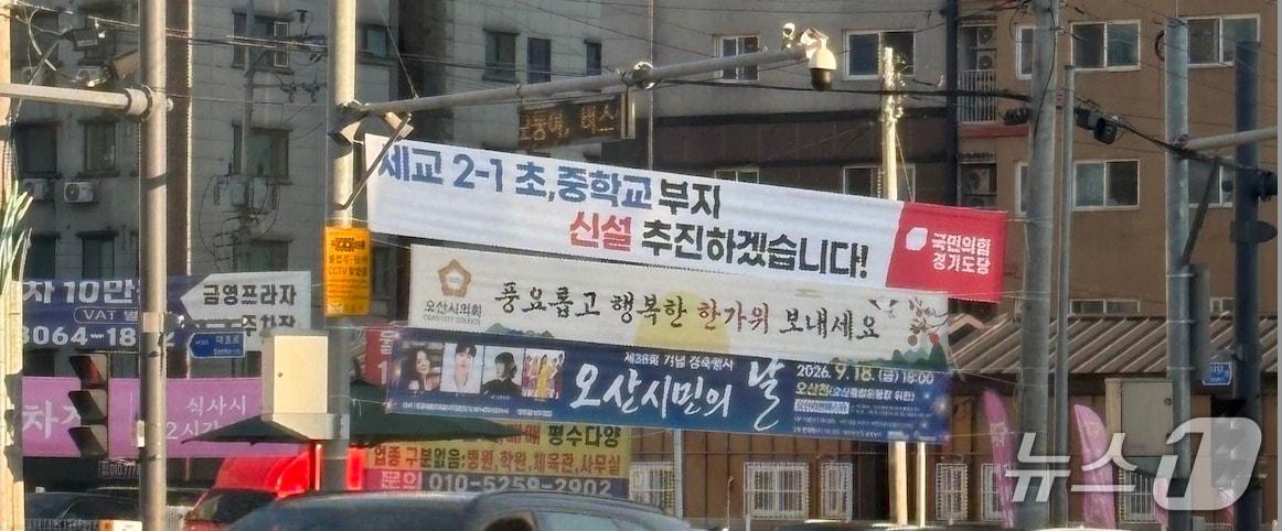 본문 이미지 - 국민의힘 경기도당 명의의 '세교 2-1 초·중학교 부지 신설 추진하겠습니다!'라고 적힌 현수막이 오산시 한 도로에 게시돼 있다. 2026.9.16 ⓒ 뉴스1 이윤희 기자 