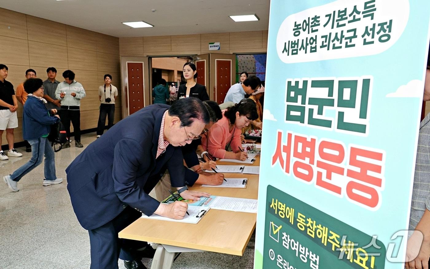 본문 이미지 - 농어촌기본소득 유치 염원 서명부에 서명하는 송인헌 괴산군수.(괴산군 제공. 재판매 및 DB 금지).2026.9.16/뉴스1