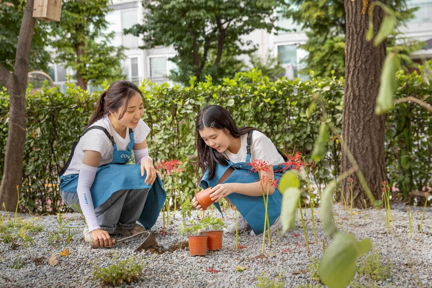 본문 이미지 -  코웨이 임직원과 서울 경일초등학교 학생들이 '코웨이 생태숲 3호' 조성 활동에 참여하고 있다. (코웨이 제공)