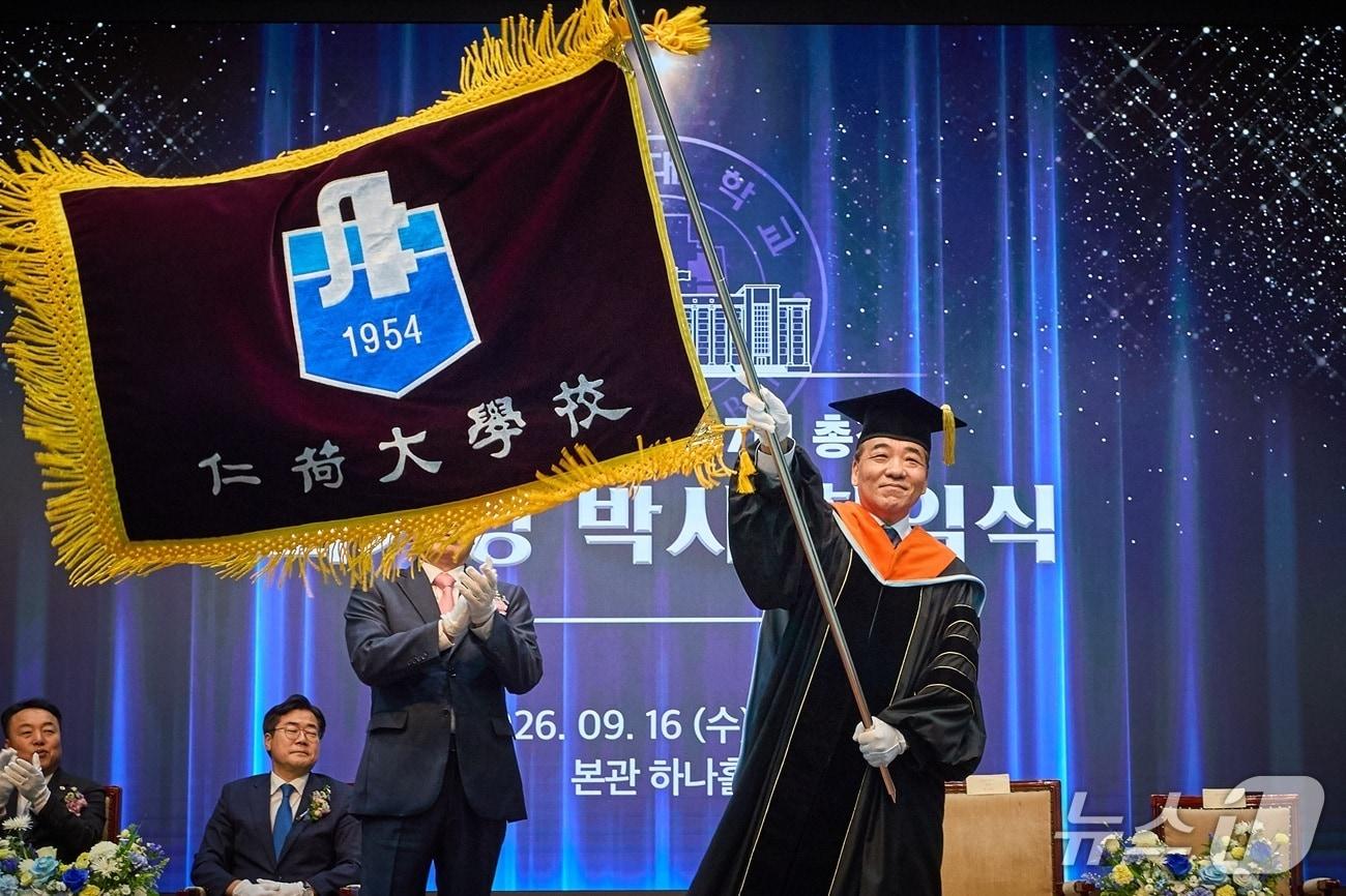 본문 이미지 - 최기영 인하대 총장이 성용락 정석인하학원 이사장으로부터 받은 교기를 흔들고 있다. (인하대 제공.재판매 및 DB금지)