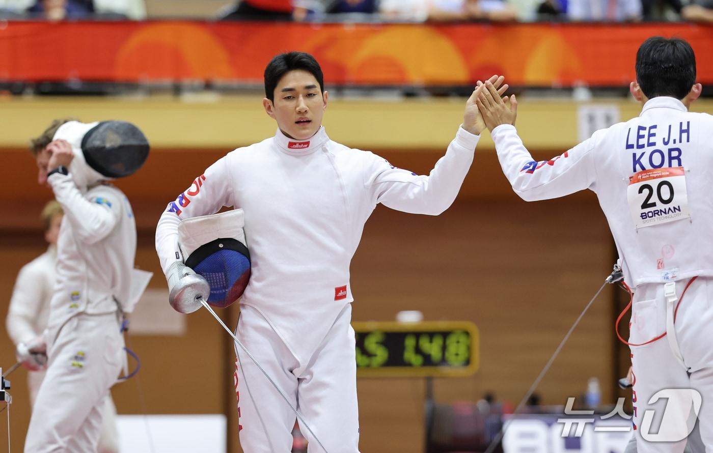 본문 이미지 - 대한민국 서창완이 16일 일본 안조 스포츠 파크에서 열린 근대5종 펜싱 시딩라운드에서 이종현과 하이파이브를 하고 있다. 2026.9.16 ⓒ 뉴스1 안은나 기자