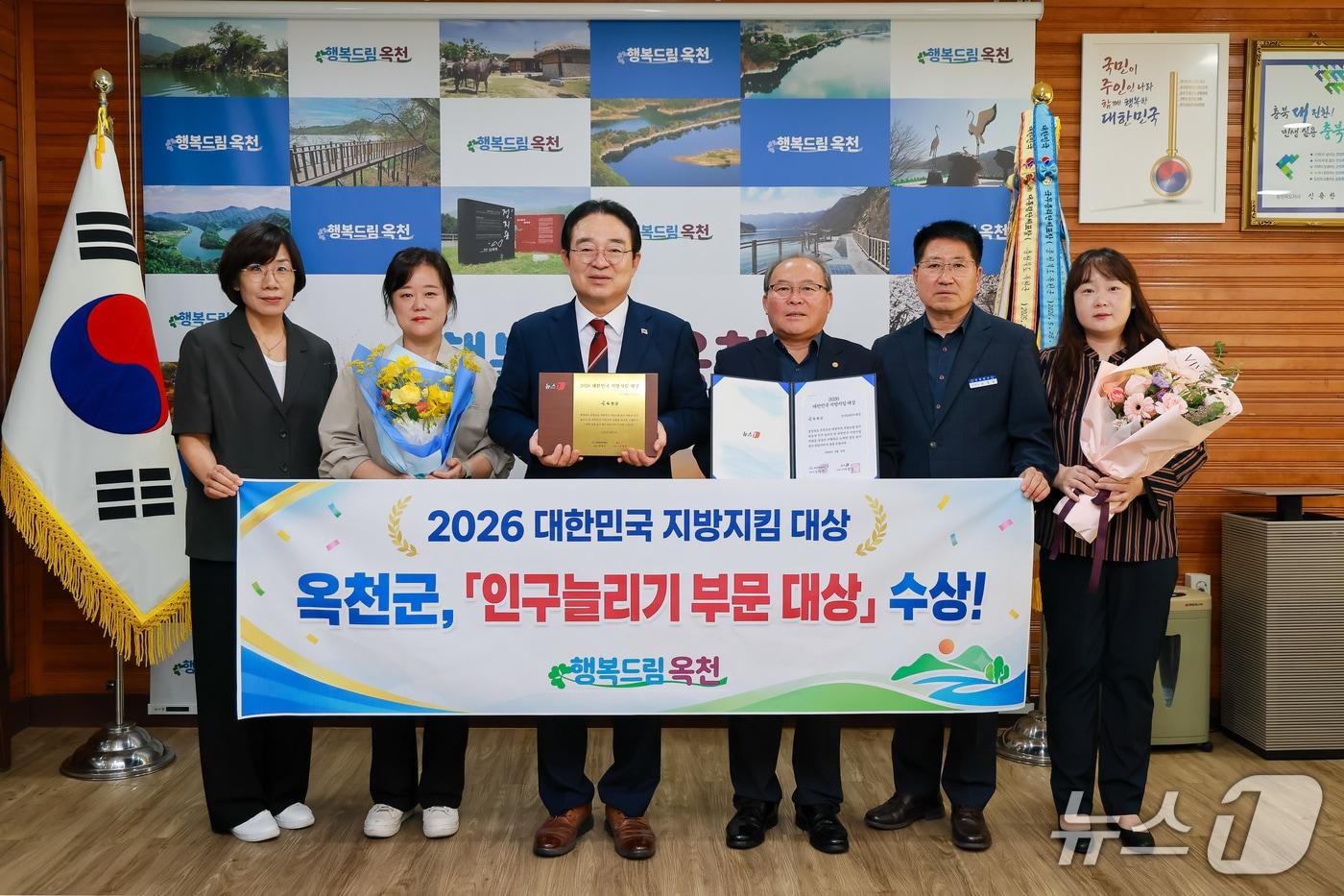 본문 이미지 - 17일 황규철 옥천군수와 직원들이 '2026 대한민국 지방지킴 대상'에서 인구늘리기 부문 대상 수상을 기념하는 사진을 촬영하고 있다.(옥천군 제공. 재판매 및 DB 금지) 2026.9.17/뉴스1