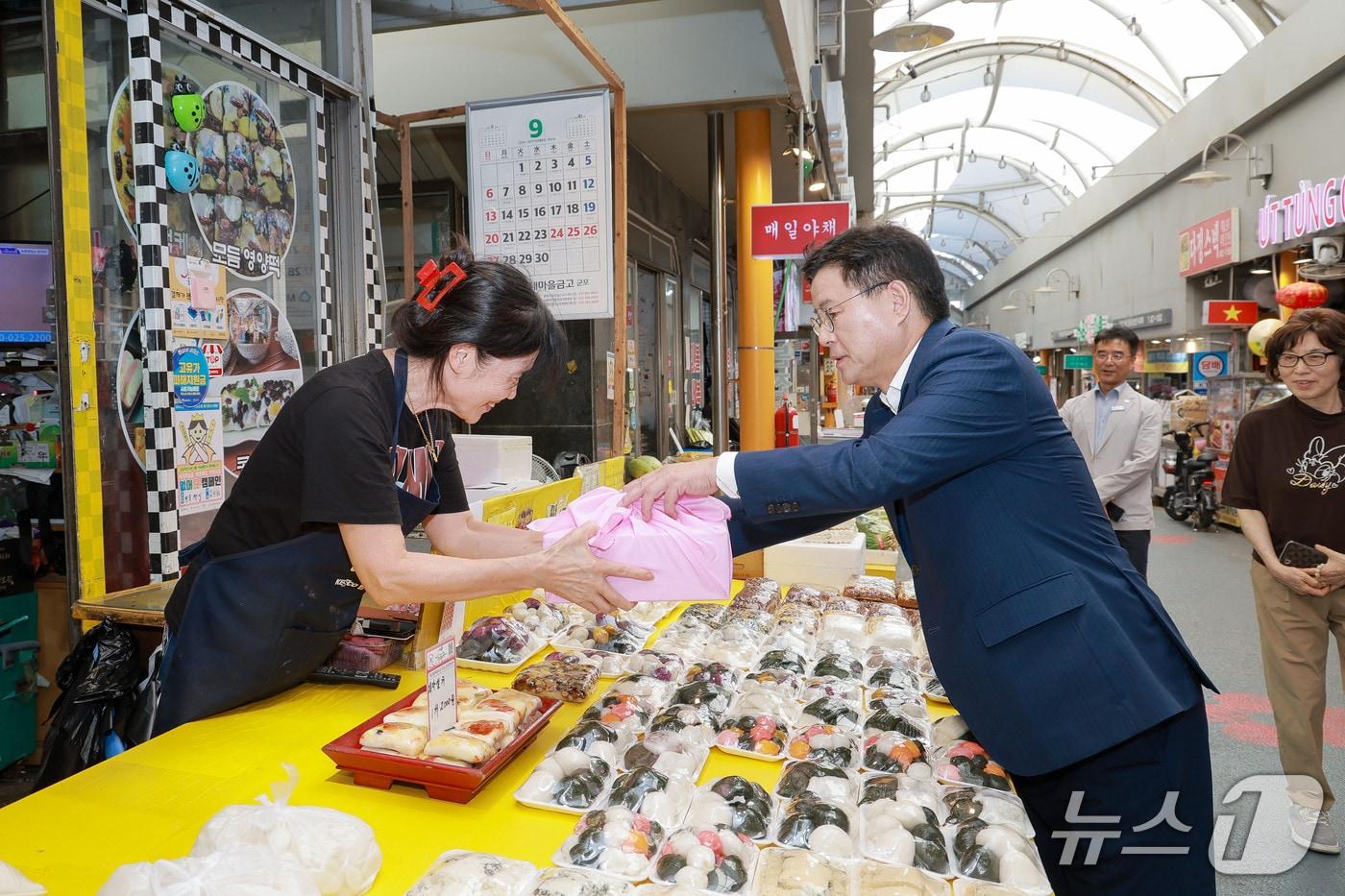 본문 이미지 - 한대희 경기 군포시장이 추석 명절을 앞둔 16일 군포역전시장과 산본시장을 차례로 방문해 온누리상품권으로 떡과 과일, 전 등 명절 먹거리를 직접 구매하고 있다. (군포시 제공. 재판매 및 DB 금지) 2026.9.17/뉴스1