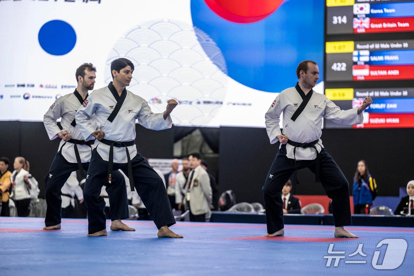 본문 이미지 - 17일 '춘천 2026 세계태권도품새선수권대회' 남자 공인품새 단체전에서 세 명의 선수가 동작을 펼치고 있다. 단체전에서는 선수들의 정확한 기술과 함께 간격과 방향, 동작의 일치도를 평가한다. (춘천시 제공. 재판매 및 DB 금지) 2026.9.17 /뉴스1