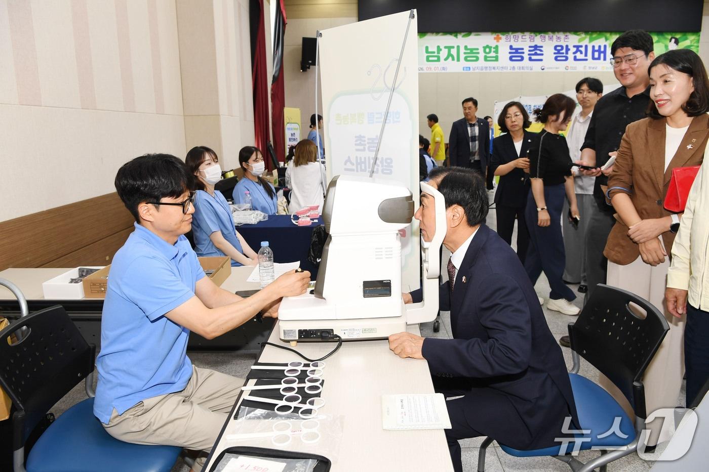 본문 이미지 - 성낙인 군수(오른쪽)가 지난 1일 남지읍 행정복지센터에 차려진 농촌 왕진버스를 찾아 의료진을 격려하고 검안을 받고 있다.(창녕군 제공. 재판매 및 DB금지)