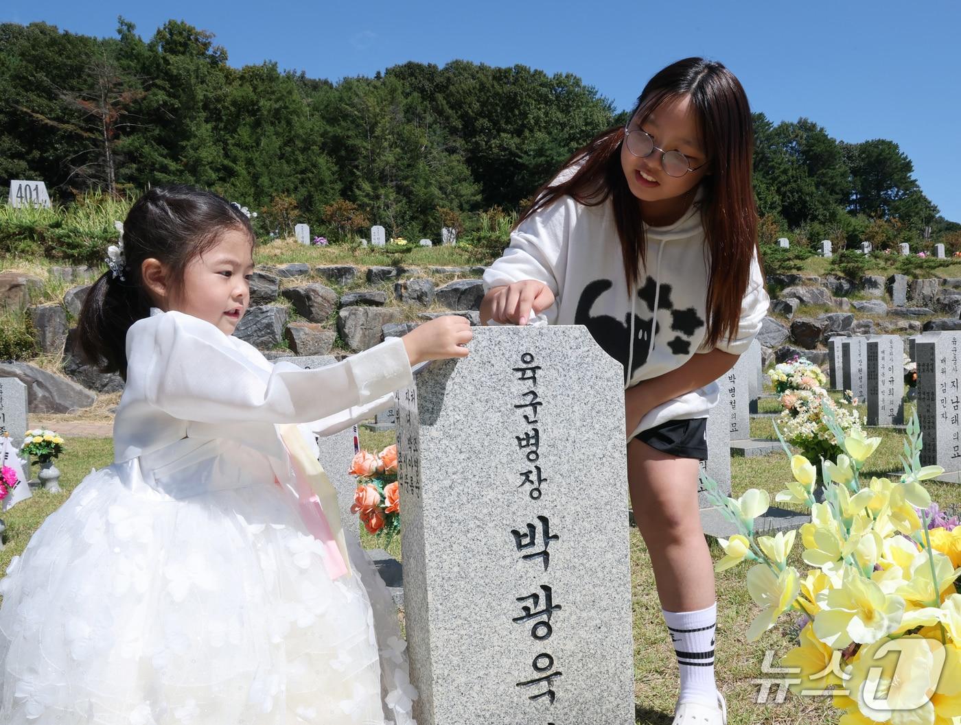 본문 이미지 - 추석 명절을 앞둔 20일 대전 유성구 국립대전현충원 모역에서 한복을 곱게 차려입은 어린이가 할아버지 묘비를 닦고 있다. 2026.9.20 ⓒ 뉴스1 김기태 기자