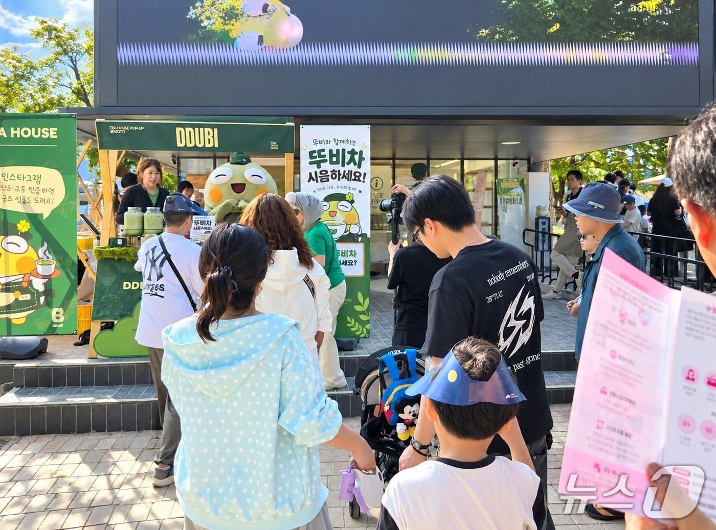 본문 이미지 - 20일 오후 대구 수성구 수성못 일대에서 열린 '2026 수성못페스티벌'에서 수성구 대표 캐릭터 '뚜비'가 운영하는 카페를 찾아 차를 시음하기 위해 줄을 서고 있다.2026.9.20 ⓒ 뉴스1 이성덕 기자