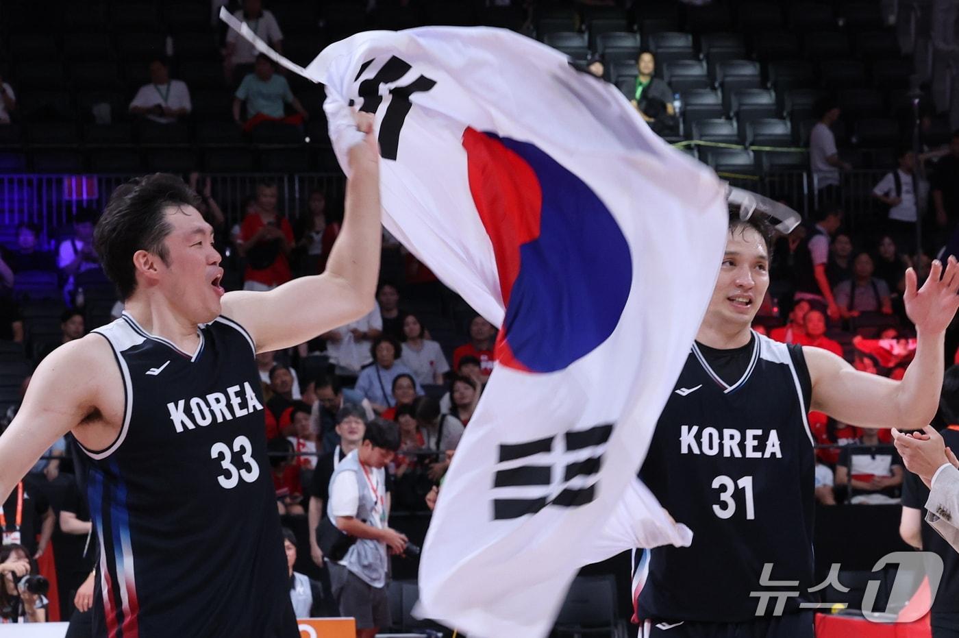 본문 이미지 - 20일 일본 나고야 아이치 인터내셔널 아레나에서 열린 2026 아이치·나고야 아시안게임 남자농구 결승전 대한민국과 일본의 경기, 12년 만에 금메달을 획득한 대한민국 이승현과 장재석이 태극기를 들고 기뻐하고 있다. 2026.9.20 ⓒ 뉴스1 안은나 기자