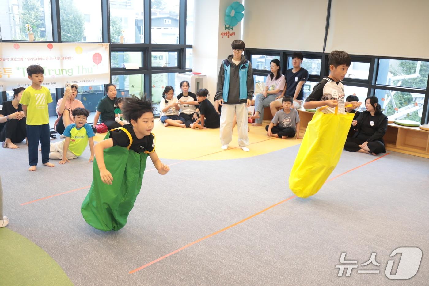 본문 이미지 - 한국과 베트남 어린이가 지난 20일 오전 울산 동구 동구가족센터에서 베트남 전통 놀이인 '냐이 바오 보'(포대자루 점프)를 하고 있다. 이날 이곳에선 베트남 추석인 '뗏중투'(Tết Trung Thu) 행사가 열렸다. 2026.9.21 ⓒ 뉴스1 박정현 기자