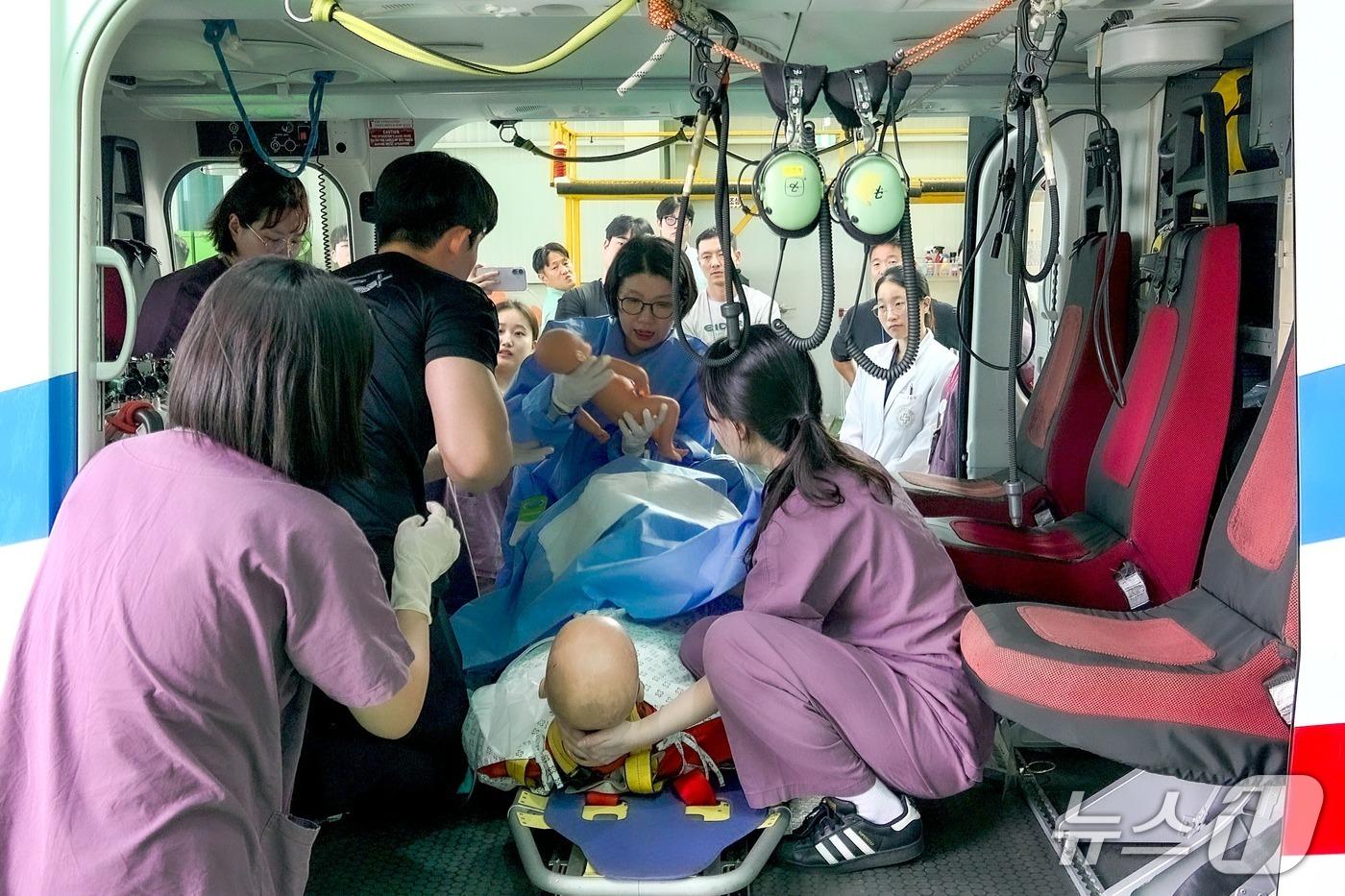 본문 이미지 - 실제 헬기 안에서 응급분만 상황을 가정한 대응 실습이 진행되고 있다.(해운대백병원 제공. 재판매 및 DB 금지)