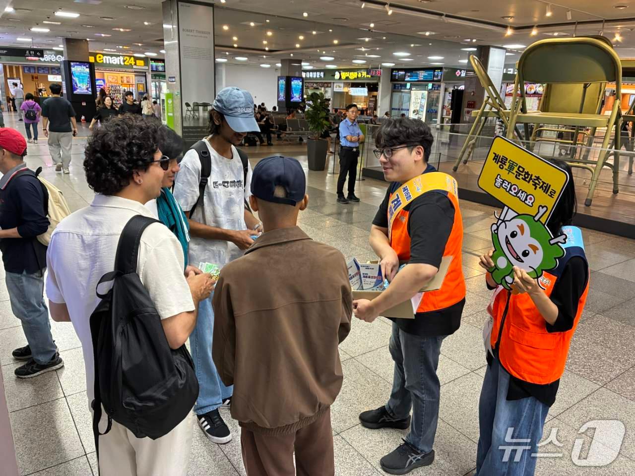 본문 이미지 - 계룡시문화관광재단 직원들이 20일 대전복합터미널에서 터미널 이용객을 대상으로 제16회 계룡軍문화축제 홍보물을 배부하며 축제 개최 일정과 주요 프로그램을 안내하고 있다. (계룡시문화관광재단 제공. 재판매 및 DB금지) /뉴스1