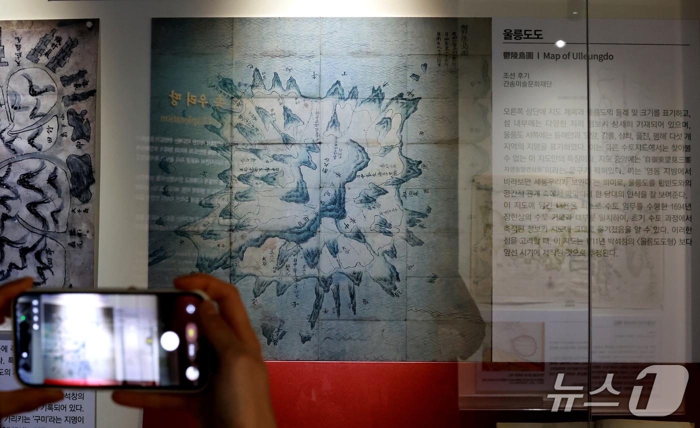 본문 이미지 - 21일 서울 영등포구 타임스퀘어에서 열린 독도체험관 기획전시 ‘하나의 지도, 두 개의 시선’ 기자설명회에서 공개된 울릉도도를 참가자들이 살펴보고 있다. 2026.9.21 ⓒ 뉴스1 이호윤 기자