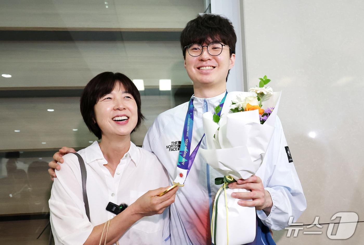 본문 이미지 - 2026 나고야 아시안게임에서 금메달을 차지한 대한민국 농구대표팀 이현중이 21일 인천국제공항 제2여객터미널을 통해 귀국해 마중 나온 어머니 성정아 대한농구협회 이사와 포옹하고 있다. 2026.9.21 ⓒ 뉴스1 박지혜 기자
