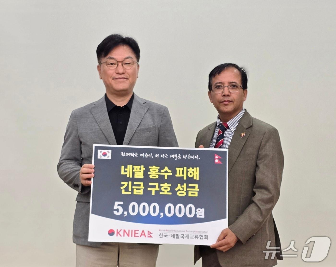 본문 이미지 - 김용수 한국-네팔국제교류협회 상임대표(왼쪽)가 21일 부산 국립부경대학교에서 니르말 프라사드 바타라이 주한 네팔 대리대사를 만나 네팔 대규모 홍수 피해 복구 및 이재민 지원을 위한 구호 성금을 전달하고 있다. (한국-네팔국제교류협회 제공. 재판매 및 DB금지)