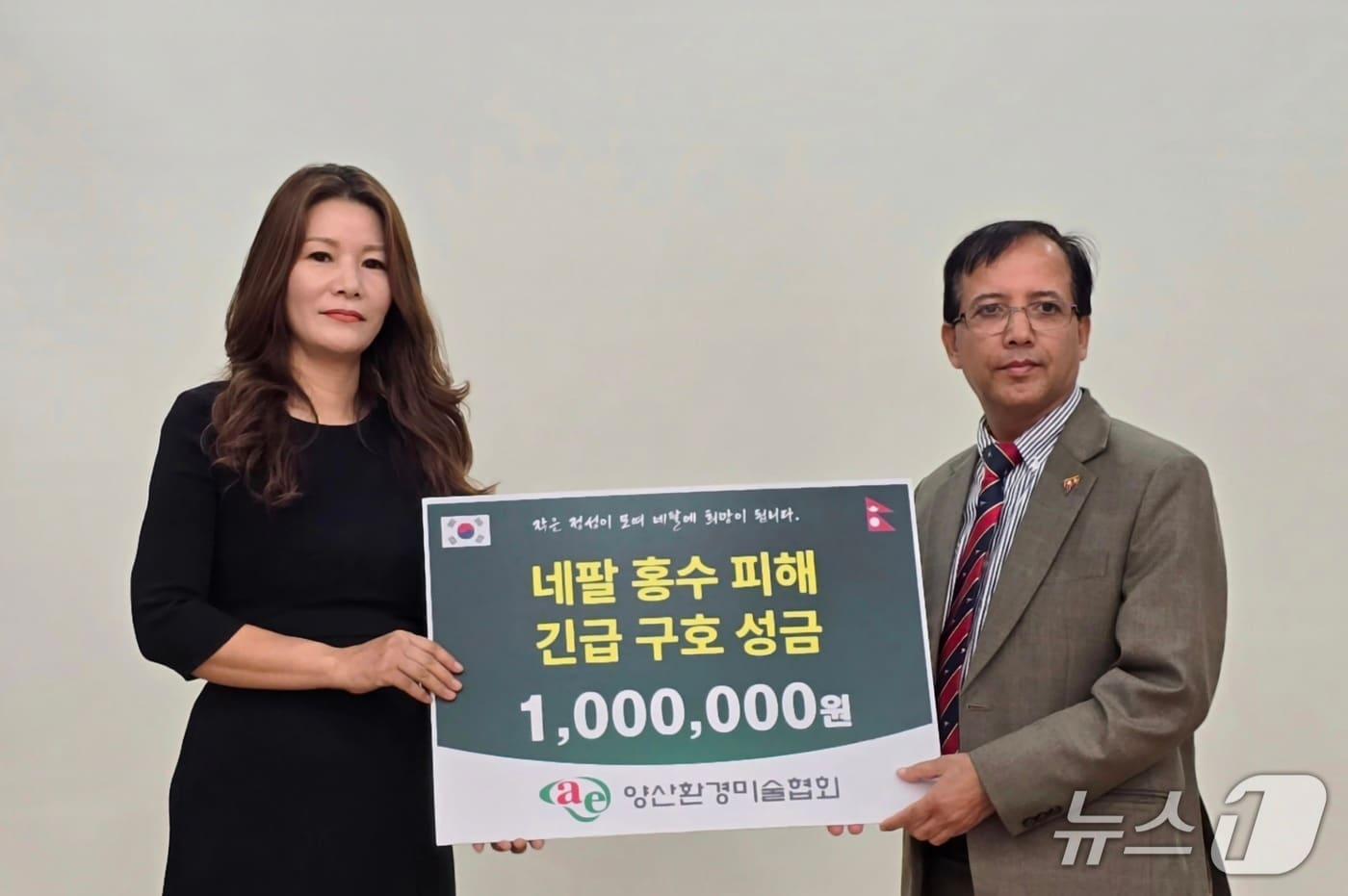 본문 이미지 - 이명희 양산환경미술협회장(왼쪽)이 지난 20일 부산 국립부경대학교에서 니르말 프라사드 바타라이 주한 네팔 대사대리를 만나 네팔 대규모 홍수 피해 복구와 이재민 지원을 위한 구호 성금을 전달하고 있다. (양산환경미술협회 제공. 재판매 및 DB금지) , 주한 네팔대사관에 홍수 구호 성금 전달