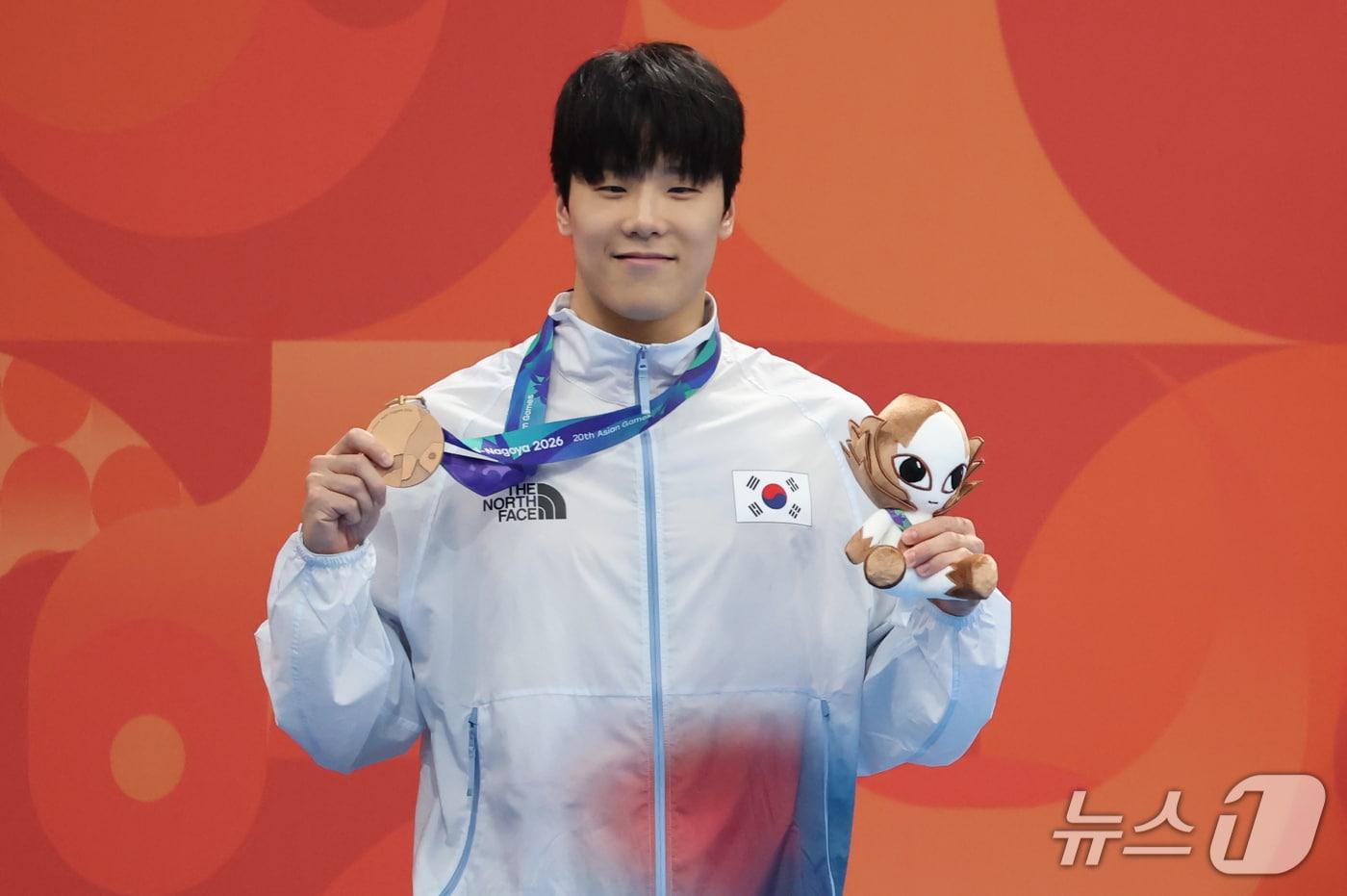 본문 이미지 - 1일 도쿄 아쿠아틱스 센터에서 열린 2026 아이치·나고야 아시안게임 남자 50m 자유형 결승전에서 동메달을 획득한 지유찬이 시상대에서 메달을 들어 보이고 있다. 2026.9.21 ⓒ 뉴스1 김민지 기자