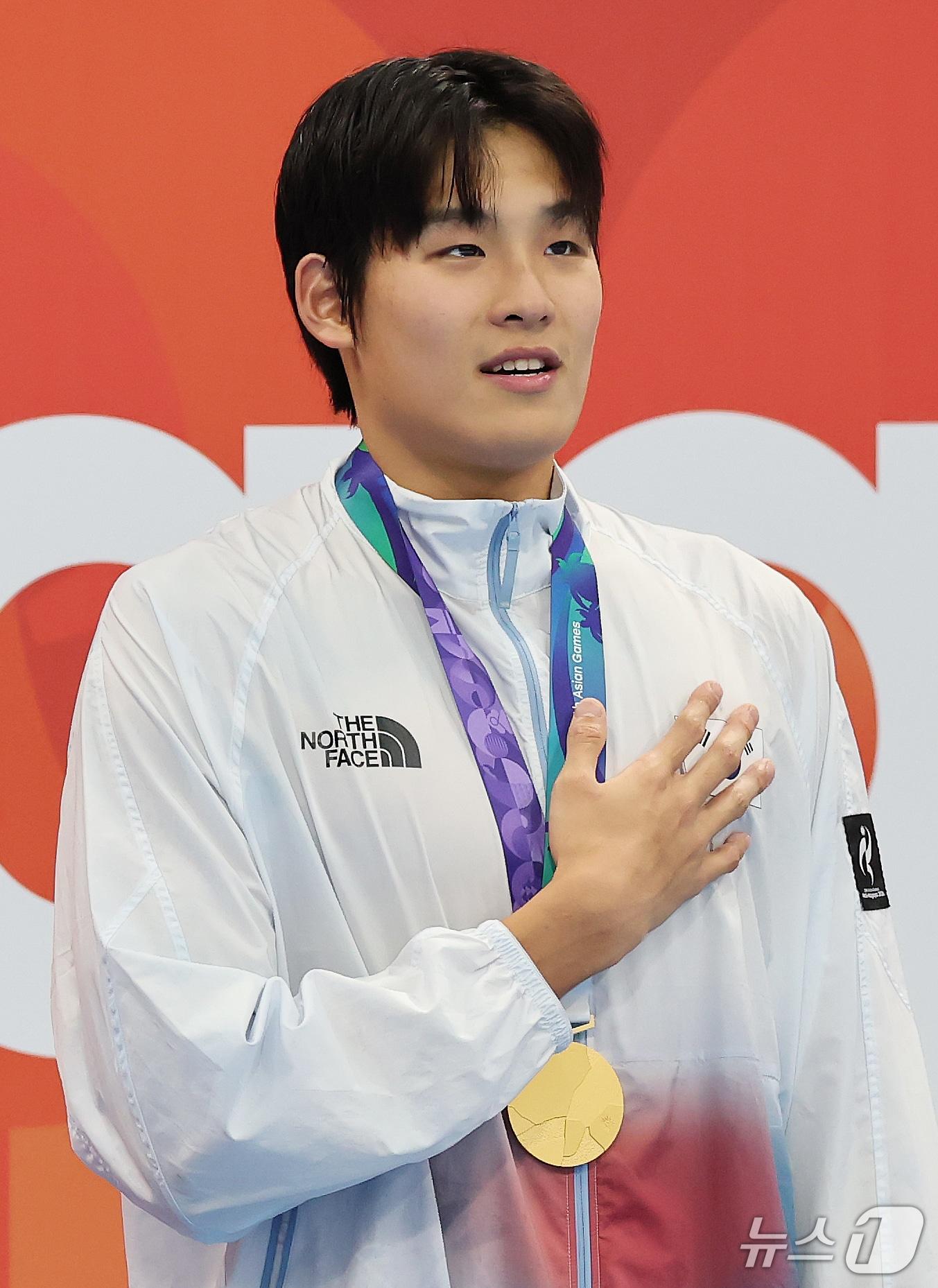 본문 이미지 - 21일 도쿄 아쿠아틱스 센터에서 열린 2026 아이치·나고야 아시안게임 남자 50m 자유형 결승전에서 금메달을 획득한 김영범이 시상대에 올라 태극기를 향해 국민의례를 하고 있다. 2026.9.21 ⓒ 뉴스1 김민지 기자