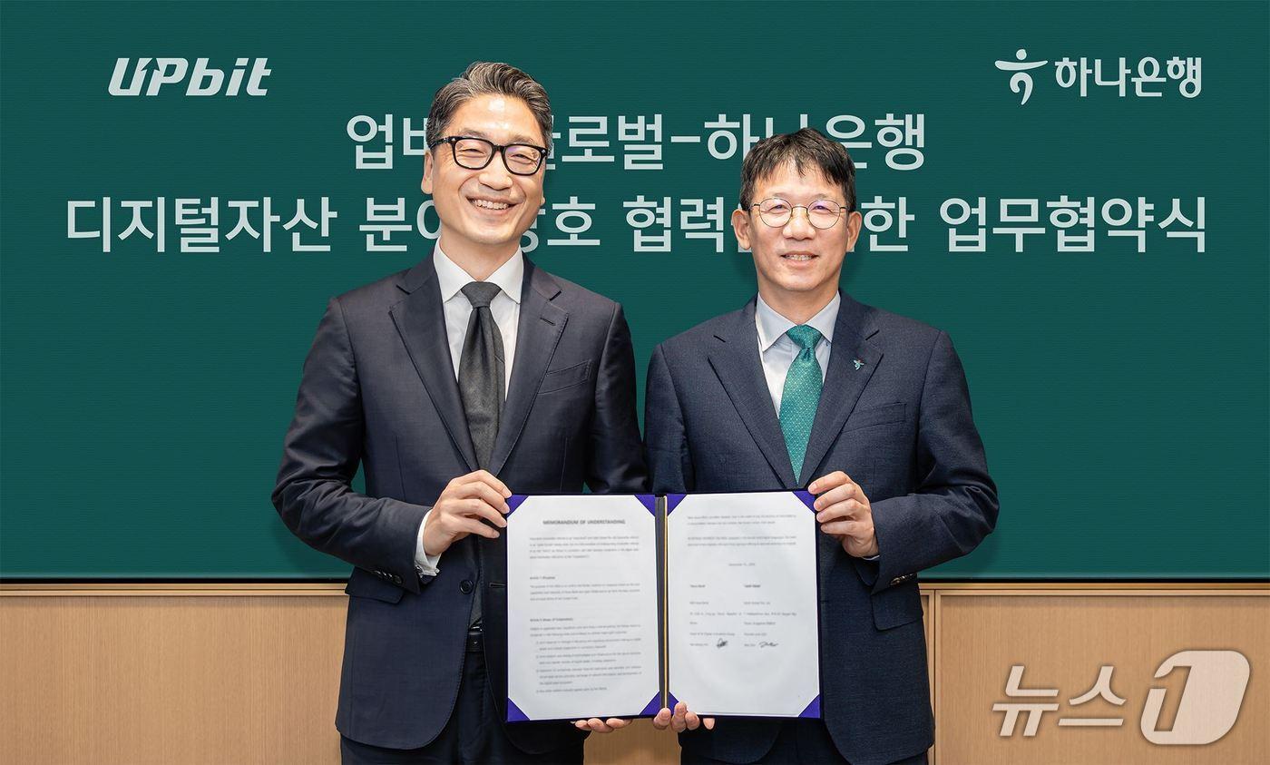 본문 이미지 - 하나은행은 지난 15일 서울시 중구 을지로 소재 하나은행 본점에서 '업비트 글로벌'과 디지털자산 분야 상호 협력을 위한 업무협약을 체결했다. 이날 협약식에 참석한 김국현 업비트 글로벌 대표(사진 왼쪽)와 엄태성 하나은행 AI디지털혁신그룹장이 기념 촬영을 하고 있다. 2026.09.15 / 사진제공=하나은행
