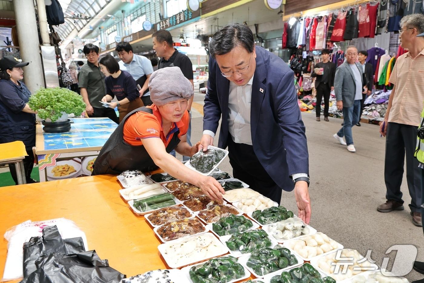 본문 이미지 - 지난 21일 김기재 당진시장이 합덕전통시장을 찾아 추석 명절 장보기를 하며 떡 등 명절 성수품을 살펴보고 있다.(당진시 제공. 재판매 및 DB 금지)