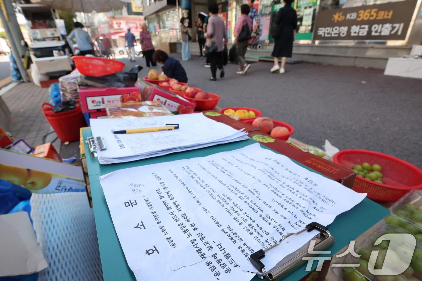 본문 이미지 - 추석을 앞둔 22일 전남광주 북구 운암동 노점에 영업 유지를 호소하는 안내문이 놓인 가운데 시민들이 장을 보거나 거리를 지나고 있다. ⓒ 뉴스1 박지현 기자