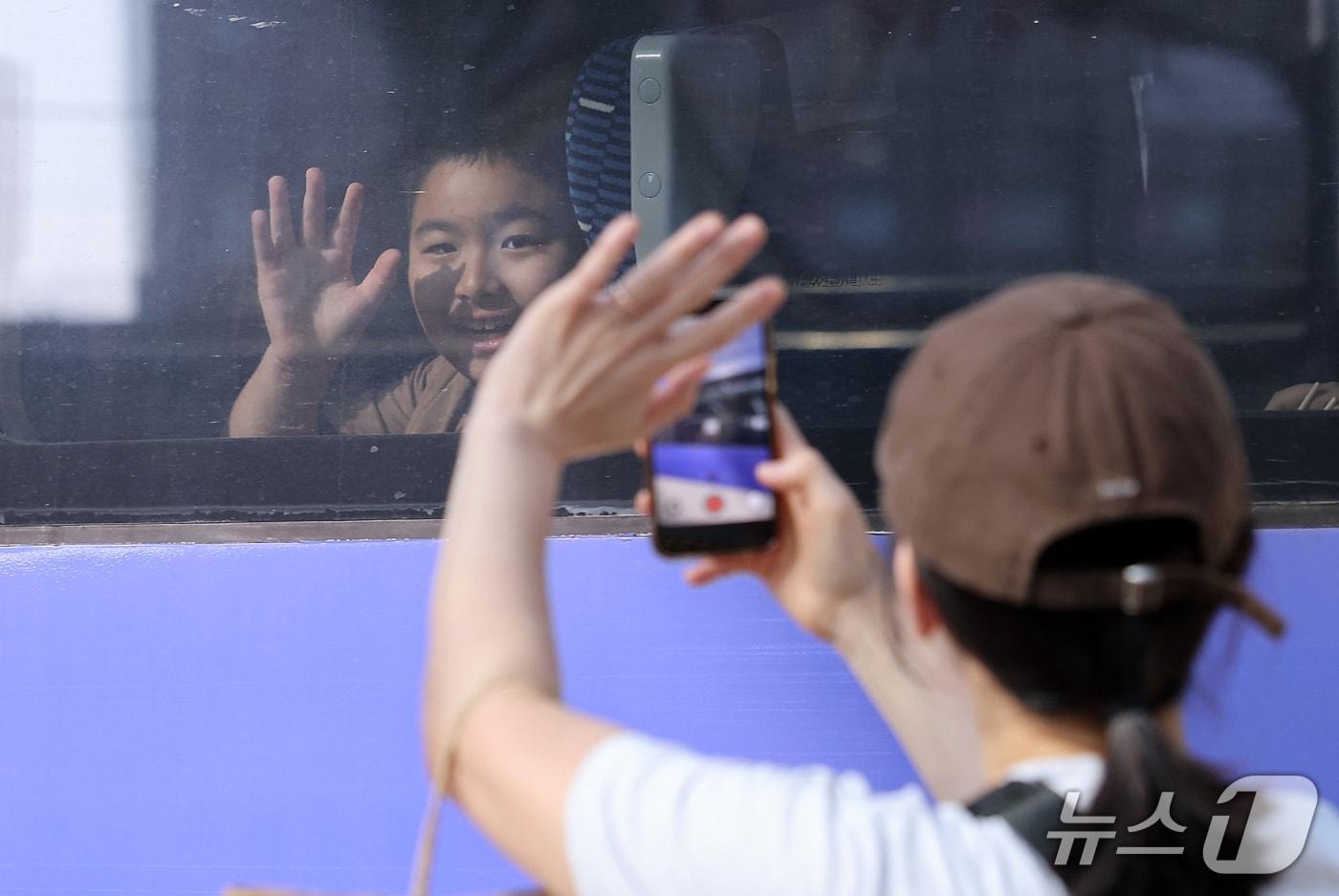 본문 이미지 - 추석 연휴를 하루 앞둔 23일 서울역에서 귀성길에 오른 어린이들이 배웅을 나온 엄마와 인사하고 있다. 2026.9.23 ⓒ 뉴스1 김성진 기자